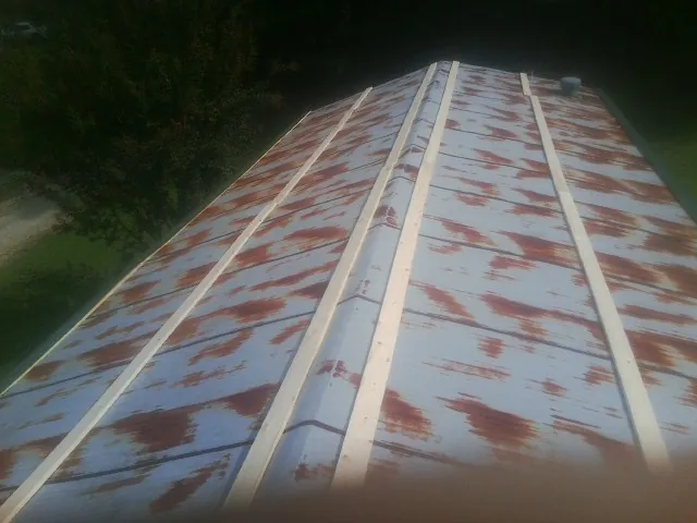 Rusted metal roof panels with new wood purlins before replacement — Storm Damage Roof Repair in Quitman by Roofing Brothers